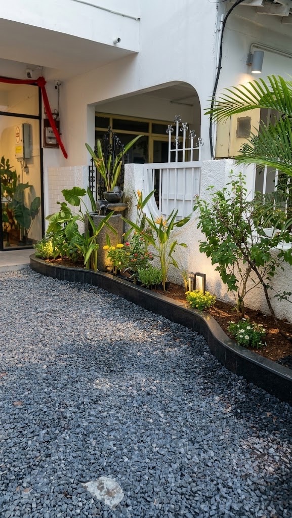 A curved, lit garden bed beside a gravel drive (Front garden)