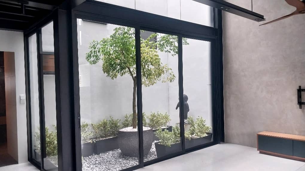 A tree and planters in a pebble courtyard (Indoor courtyard)