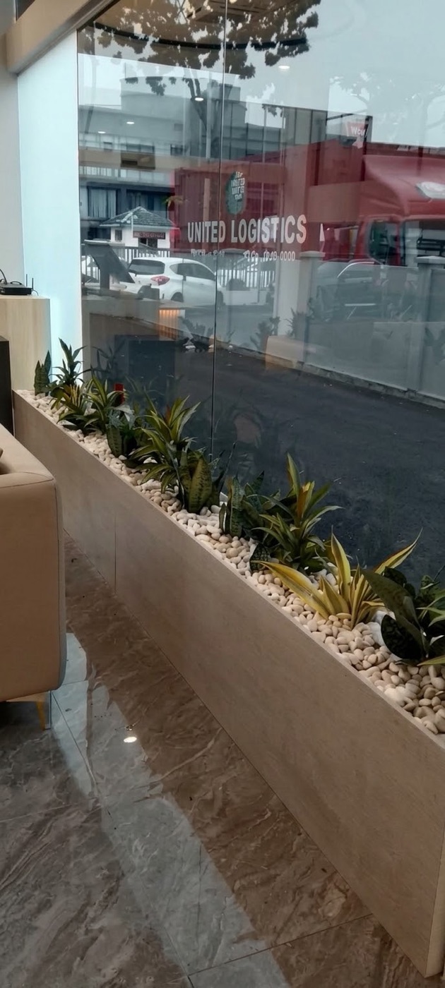 Office: A long built-in planter under the window, topped with pebbles. Landscaping by 54 Weng Thye Nursery & Landscapes.