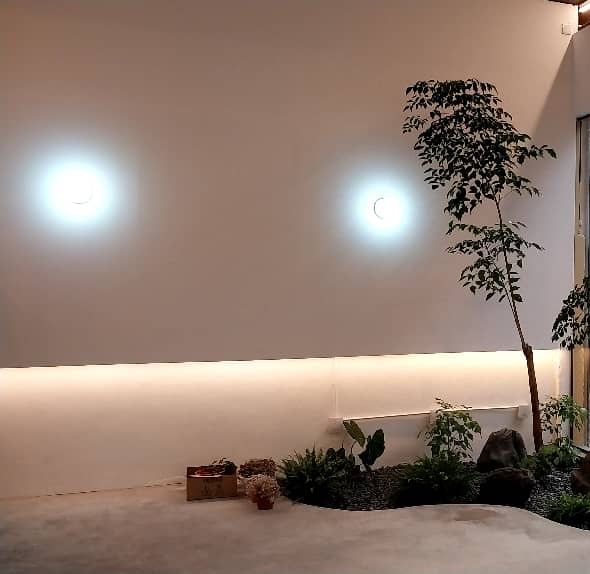 Shop: An indoor garden bed with rocks and a tree. Landscaping by 54 Weng Thye Nursery & Landscapes.